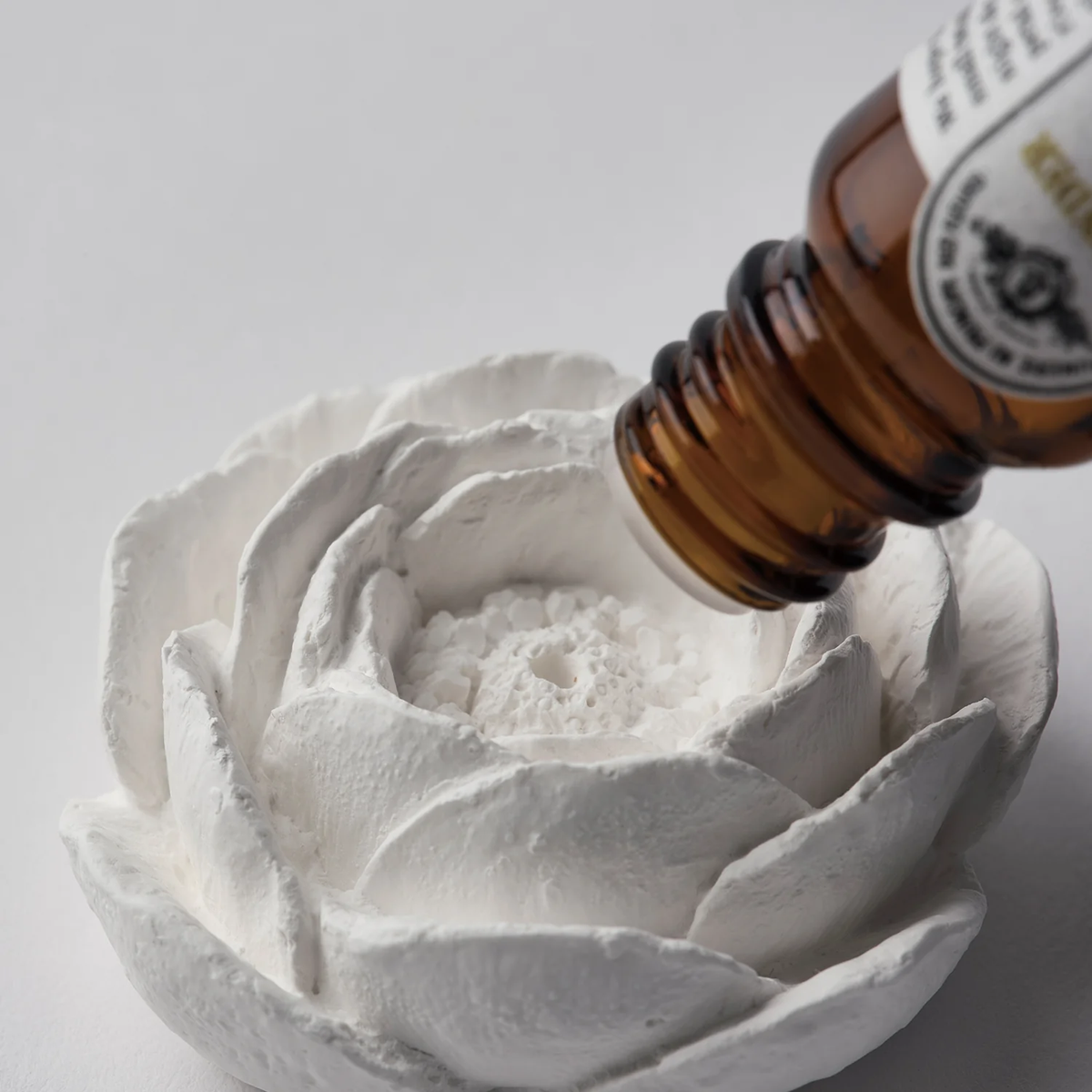 essential oil being poured on incense holder camellia